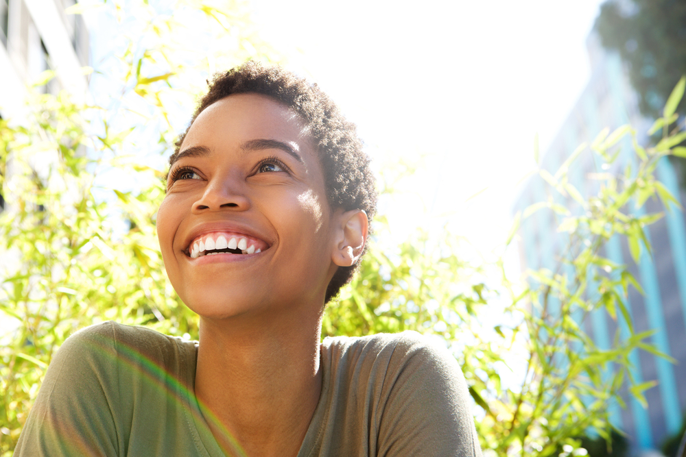 A woman smiles after her dental bonding procedure.